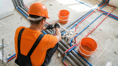 Plumber installing new water pipes in a building under construction, focusing on plumbing system installation and renovation, realistic construction photography.