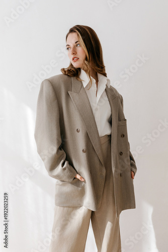Woman in tailored beige suit with white shirt
