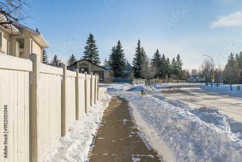 Clean sidewalk  after snow  removed along house property fence in winter season day