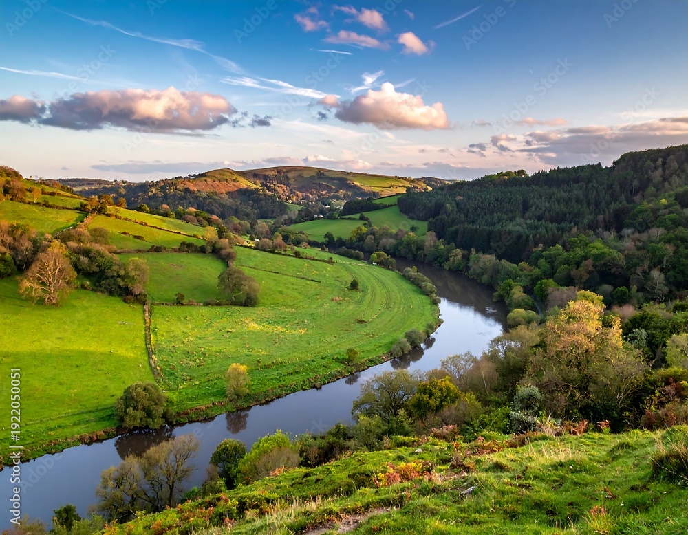 Fototapeta premium A vibrant vista of a serpentine river weaving through verdant valleys and rolling hills under a partly cloudy sky at sunset