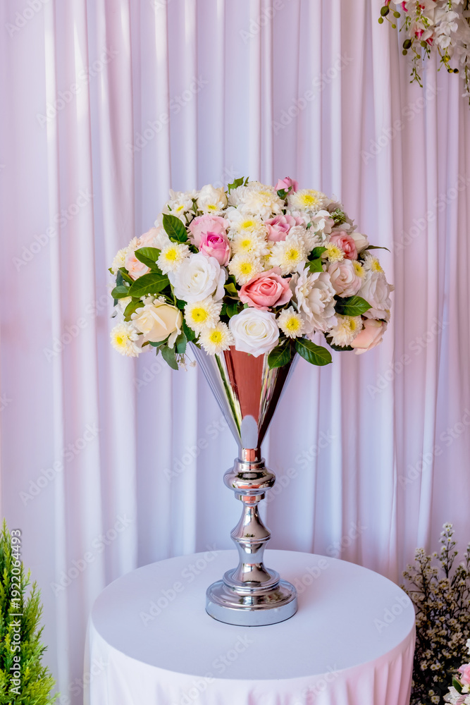 Obraz premium Beautiful floral arrangement on elegant silver vase for wedding or event decoration