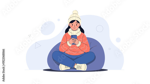 Young Woman Sitting on Beanbag Chair Using Smartphone in Winter Clothing