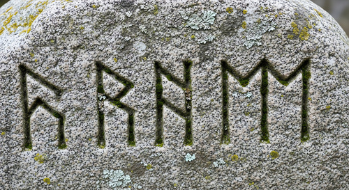 Ancient Stone Rune Inscription: Discover an ancient stone inscription of mysterious runes, hinting at a forgotten past and the secrets it holds. Carved into the weathered surface of a timeless stone.