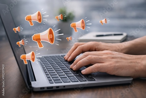 Promoting brand awareness and expanding online audience reach, a hand typing on laptop keyboard with megaphone floating icon graphics radiating above the screen in bright office light.