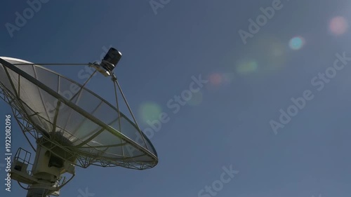 Satellite Dish Antenna Against Clear Blue Sky With Sun Flare. 4k Footage Video