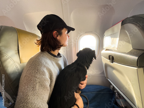 Woman With Dog Looking Out Airplane Window