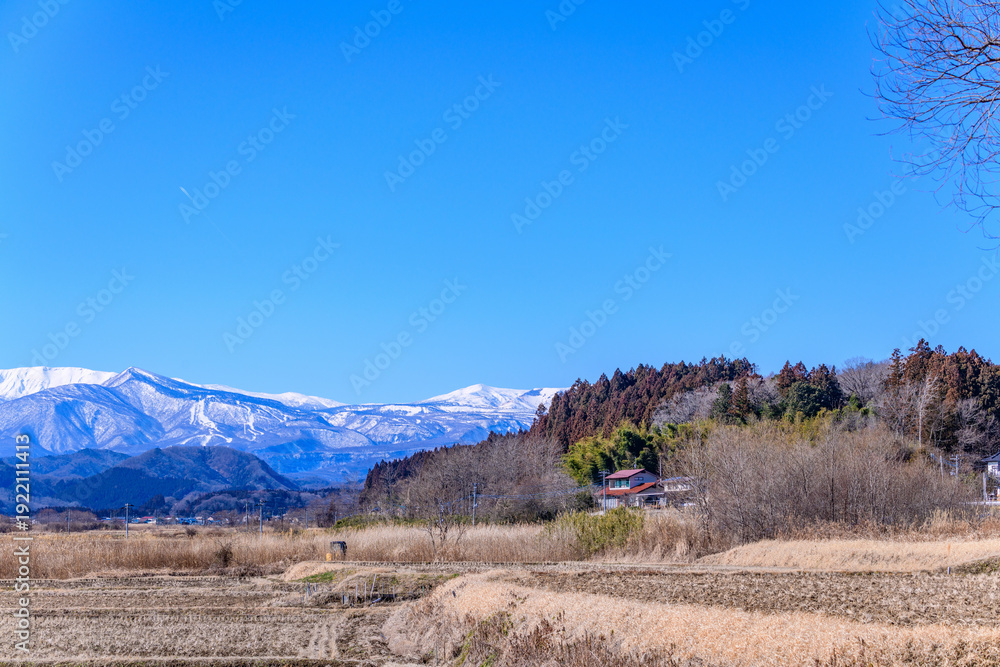 Fototapeta premium 雪の蔵王と青空と春を待つ里山 