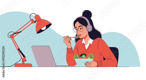 Young woman wearing headphones and glasses eats a healthy salad while working on a laptop at her desk under a red lamp.