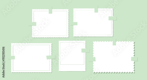 Collection of blank white vintage photo frames with scalloped edges attached to a light green background with small pieces of masking tape.