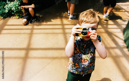 Child uses a disposable camera while on vacation