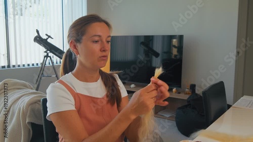 Wallpaper Mural Woman works on combing long hair preparing it for extension while sitting in a room with a telescope Torontodigital.ca
