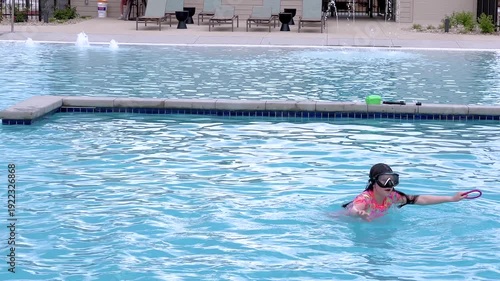 Young Girl Enjoying a Swim with Goggles in the Pool