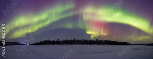 Canvas Print Stunning Aurora Borealis dancing over frozen Lake Inari and snowy forest in Ival