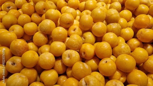 Fotografie Yellow round plums on a shop window, yellow fruits and vitamins for proper nutri