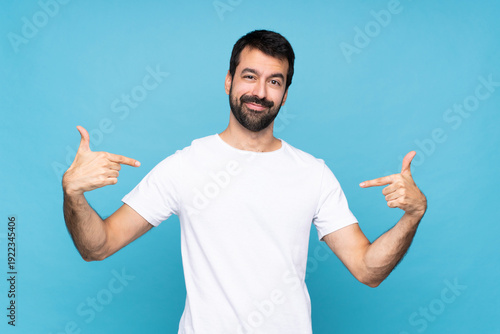 Young man with beard  over isolated blue background proud and self-satisfied