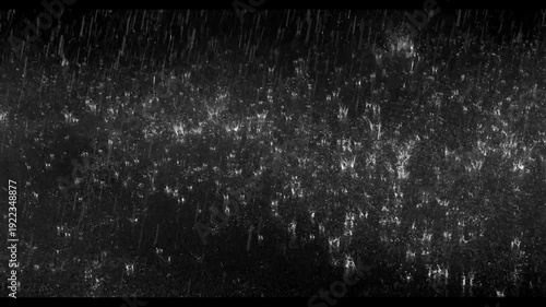 Realistic rain drops hitting the ground creating beautiful water splashes on a dark black background. Perfect cinematic rain overlay for video editing, visual effects, films, trailers, music videos
