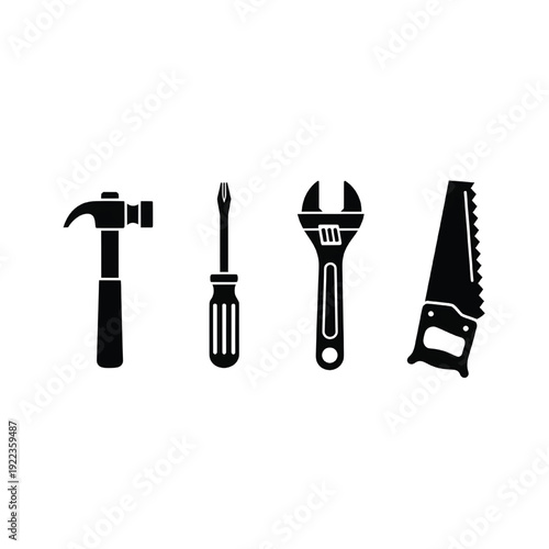 A set of four essential hand tools lie on a workbench indoors.