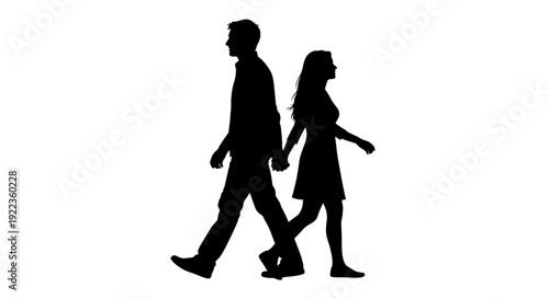 Silhouetted couple walking hand in hand in love