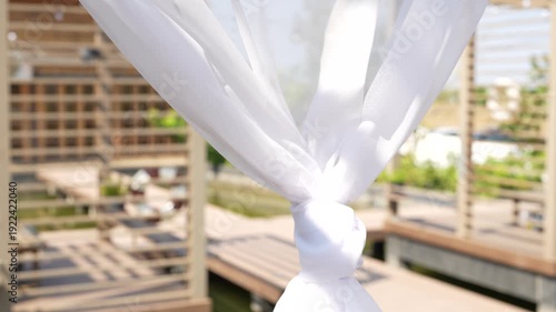 Elegant White Fabric Draped in Soft Breeze with Wooden Deck Background in a Beautiful Outdoor Setting