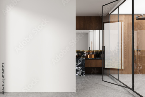 Contemporary bathroom interior with open glass door, marble sink, wood paneling and a large empty white wall for poster mockup or design template display. 3D Rendering