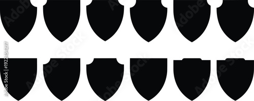 Set of twelve black shield silhouettes with various classic shapes and crest outlines, perfect for security branding, heraldry design, and protective icon sets.