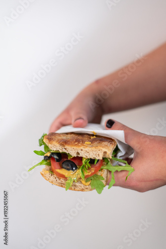 Focaccia with rosemary and salt, filled with tomato, mustard, arugula and olives