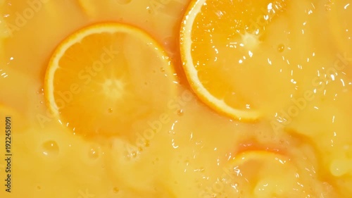 Fresh citrus orange fruit falling in slow motion into juice with vibrant splashes.