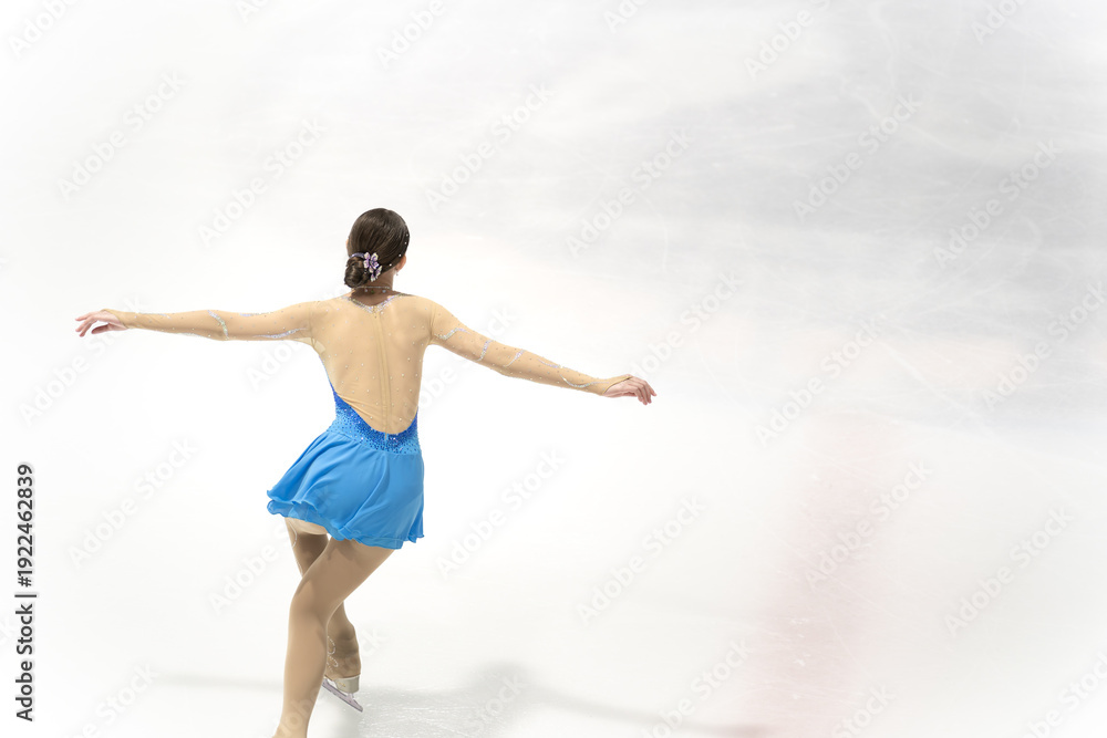 Fototapeta premium Graceful Ice Skater Performing Elegant Move on Frozen Surface