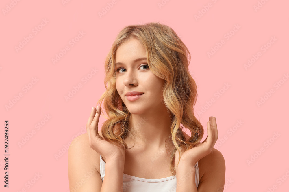 Obraz premium Blonde young woman with curly hair on pink background