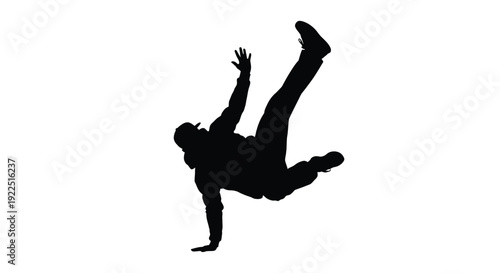 Dynamic breakdancer performing a power move captured in dark silhouette