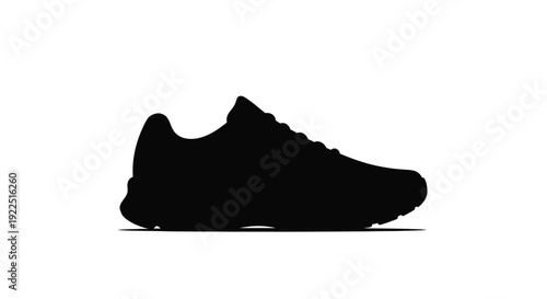 A black sneaker rests on a white surface stark silhouette