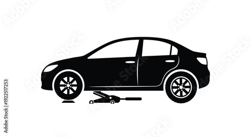 Black car being jacked up for repair striking silhouette