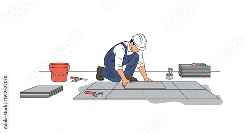 A construction worker in a hard hat lays grey floor tiles, surrounded by tools and a red bucket.