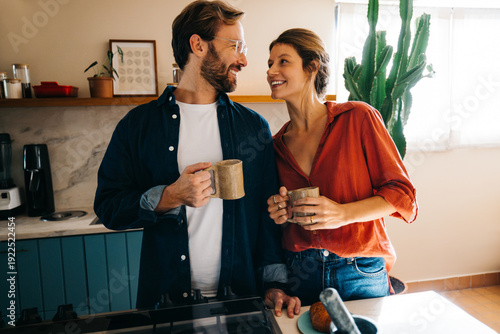 Fényképezés Couple sharing coffee and smiles in cozy sunlit kitchen