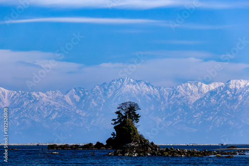 富山・雨晴海岸から望む冠雪の立山連峰と女岩の絶景