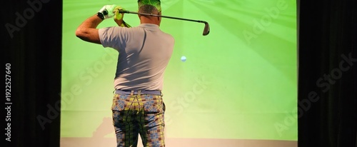 Billede på lærred Professional male golfer holding club playing golf indoors on golf simulator con