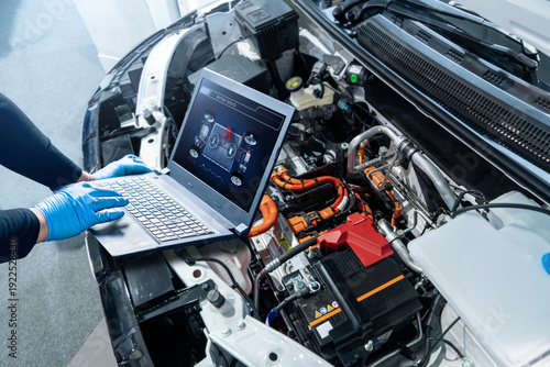 Фотография Technician checks the battery pack of an electric car at a service center