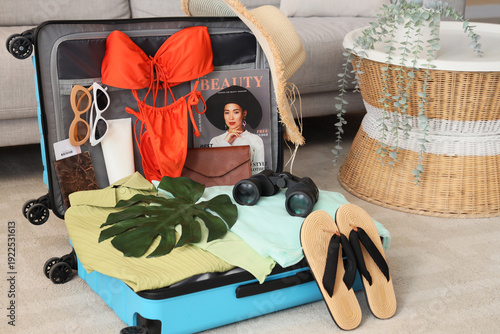 Open suitcase with beach ac...
