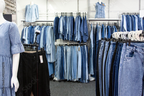 Fényképezés Wide variety of denim clothes neatly arranged on hangers in a clothing store interior