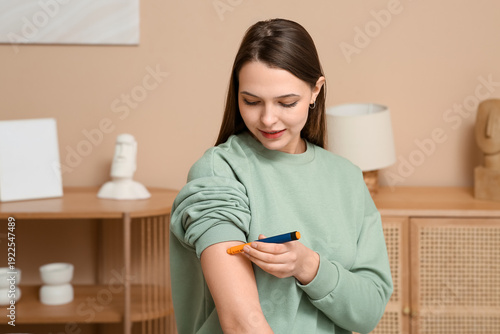 Obraz na plátně Diabetic woman giving herself insulin injection at home