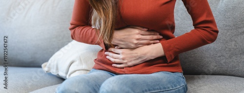 Fotografie asian young woman intolerance hand in stomach ache, suffer from food poisoning,