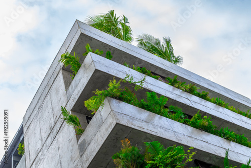 Modern architectural building with lush greenery and concrete design