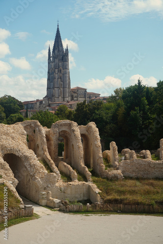 View of the gothic bell tower of Basilique Saint-Eutrope seen from the ancient Gallo-Roman amphitheater in Saintes, France. A unique perspective combining Roman heritage and medieval architecture