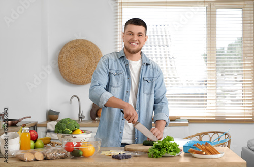 Young man cutting vegetable...