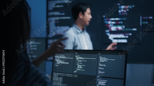 Male software engineer presenting a Coding Task, AI chatbot workflow with code on multiple monitors in a modern office. coding collaboration and agile projects Concept.