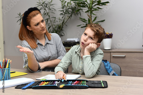 Frustrated woman helping her son with school studies, child feeling stressed and overwhelmed by learning.