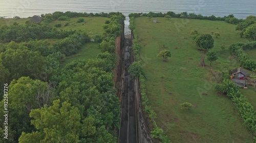 Drone flying backward revealing Tanah Barak cliffs, Indonesia