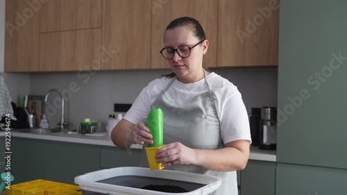 Woman prepares soil for seedlings in the kitchen, home gardening