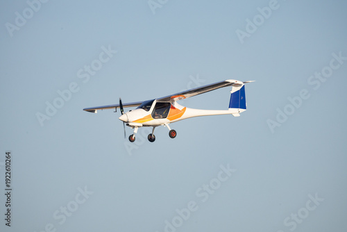 Light sport aircraft flying against clear blue sky