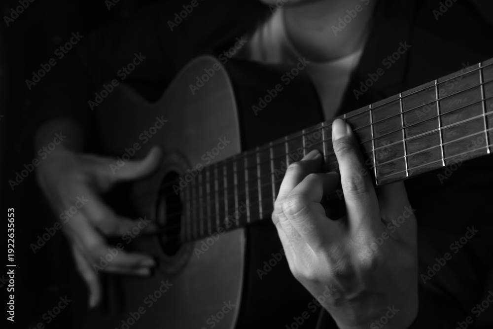 Fototapeta premium Close up of musician playing classical guitar in black and white